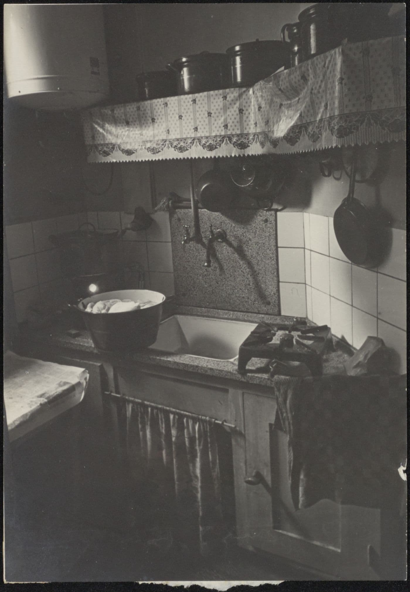 Niegeman verzamelde foto's voor zijn boek 'Ik kan wonen'. Dit is vermoedelijk hoe het niet moest. De keuken is krap en slecht verlicht. De ruimte iets naar voren hellend fotograferen helpt ook niet: net zo min als die pan aardappelen die daar o… 