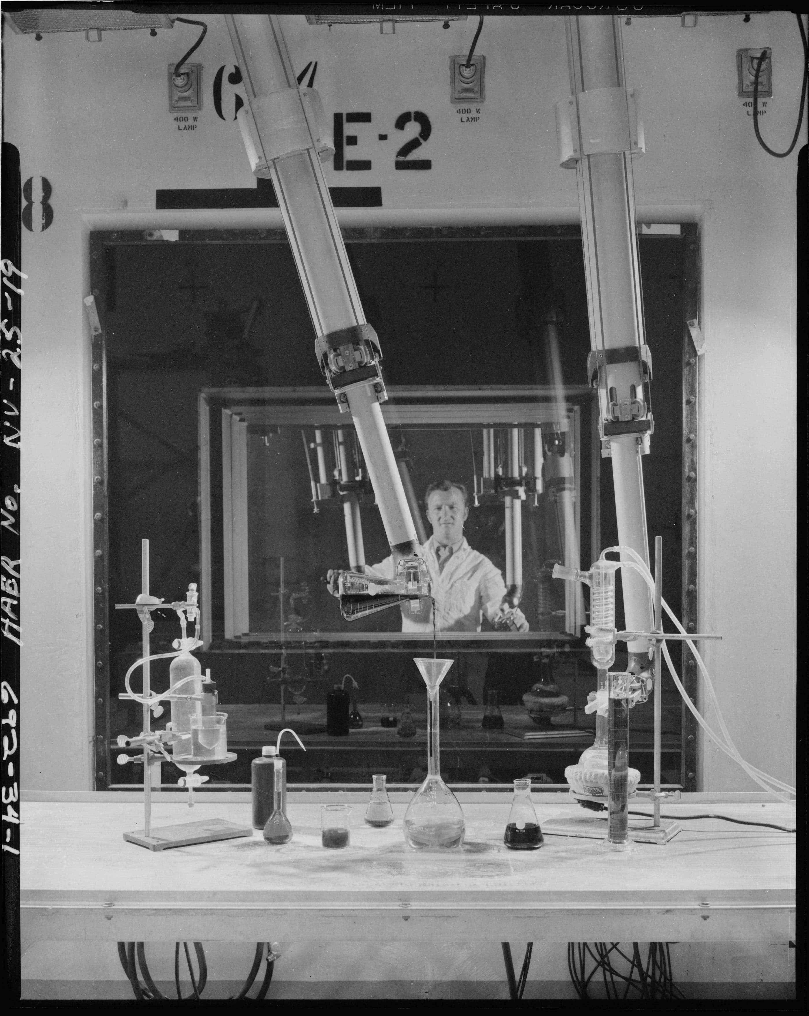 Worker manipulating small glass objects in the hot bay with manipulator arms. Photographer unknown, ca. 1969. Repository: Library of Congress. 