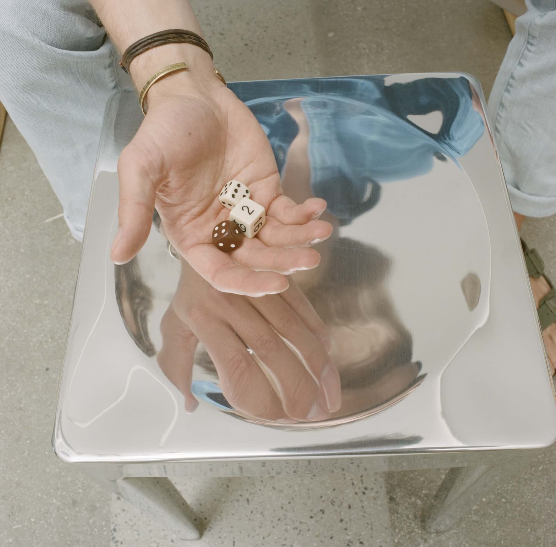 Dobbelstenen bovenop een gepolijste aluminium Emeco Stool (2001). Ontwerp Emeco Stool: Philippe Starck. Gefotografeerd als onderdeel van het 'Emeco Abides' foto-essay in Disegno #32. Foto: Ramak Fazel. Beeld met dank aan Disegno.