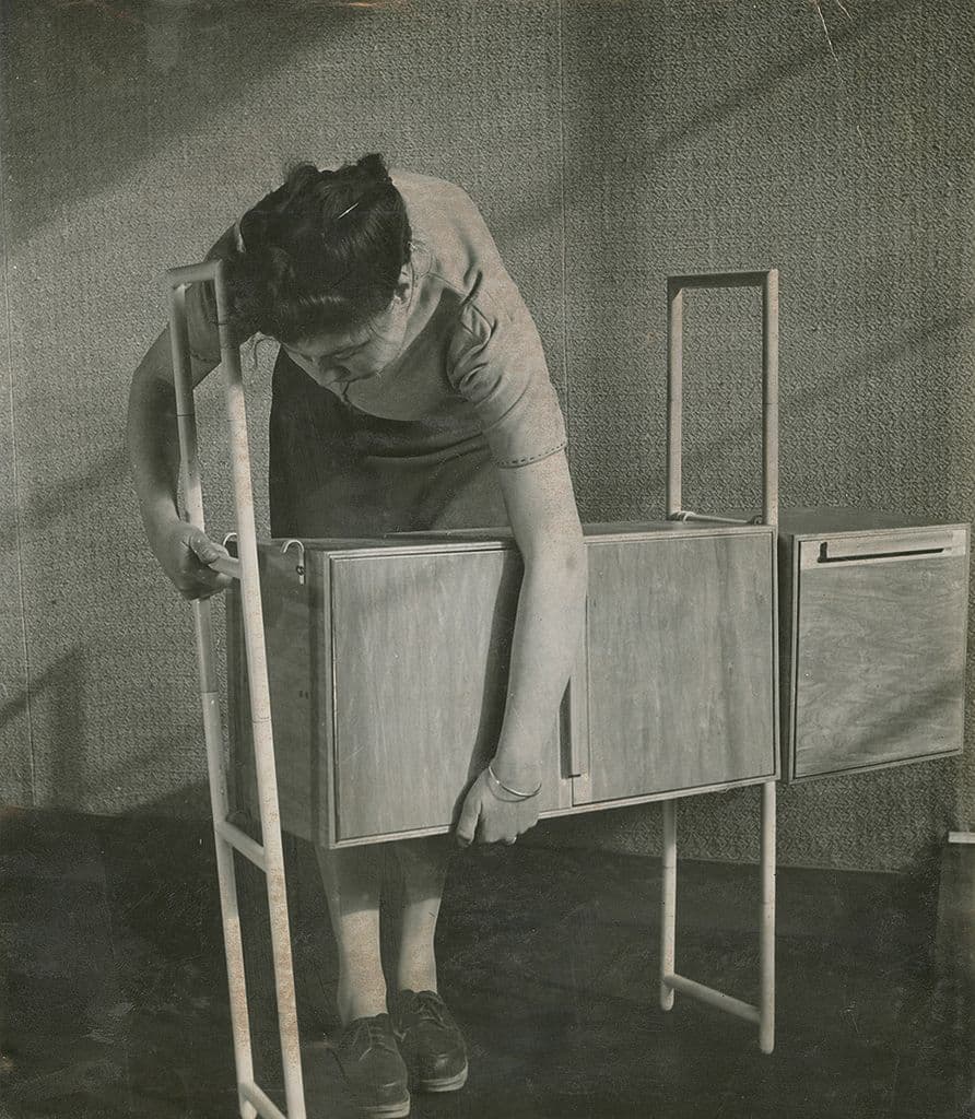 Vrouw monteert een kast uit het PIRU meubelsysteem. Een belangrijk thema in Architecture the Dutch Way 1945-2000 is het ontwerpen voor de ‘gewone mens’.  A.Bueno de Mesquita. 1948. Fotograaf onbekend. Collectie Het Nieuwe Instituut, BUON 2…