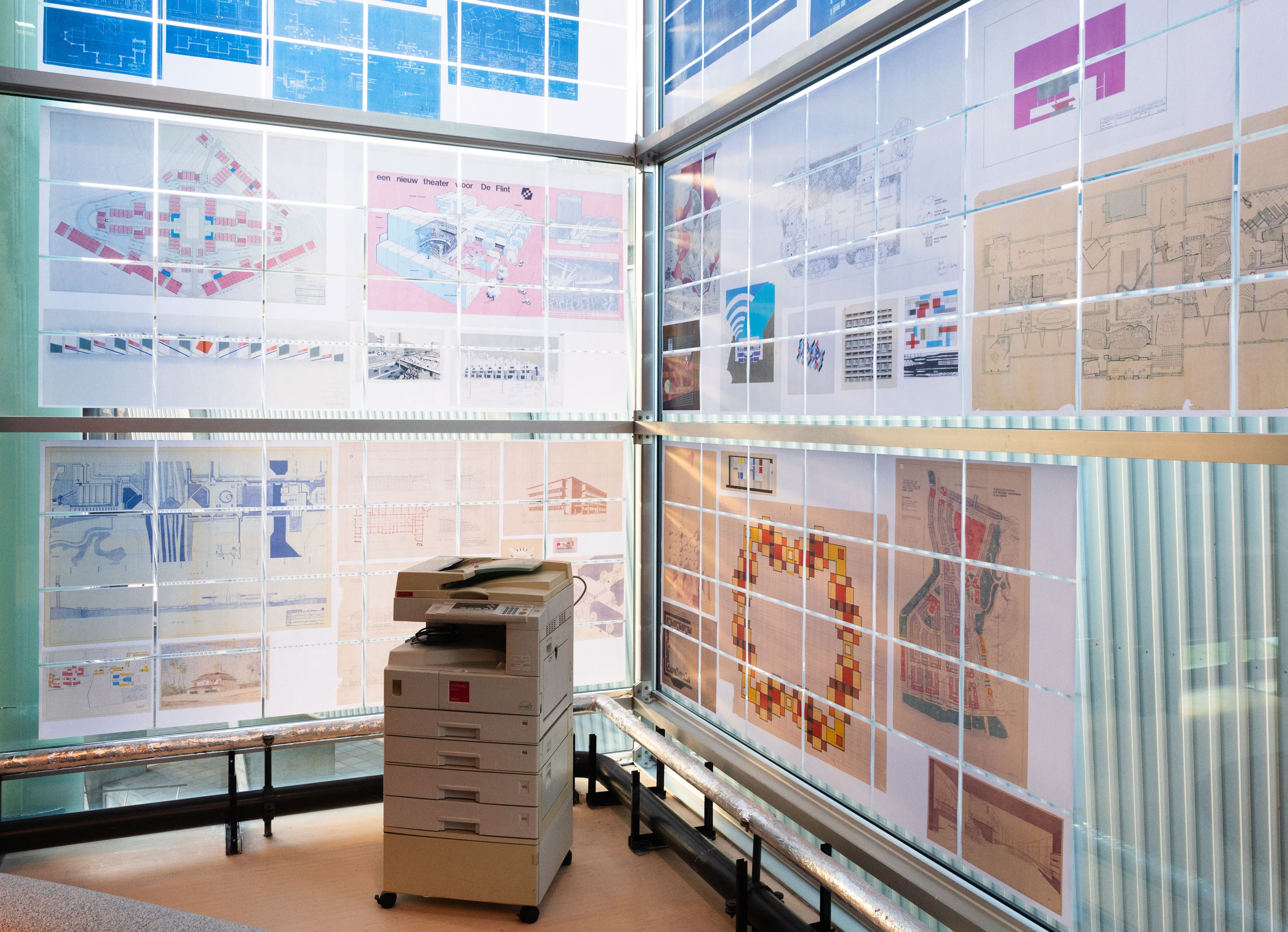 Copy Corner in het Research Centre. Ouderwets kopieerapparaat tegen een hoekraam die helemaal beplakt is met kopieen.
