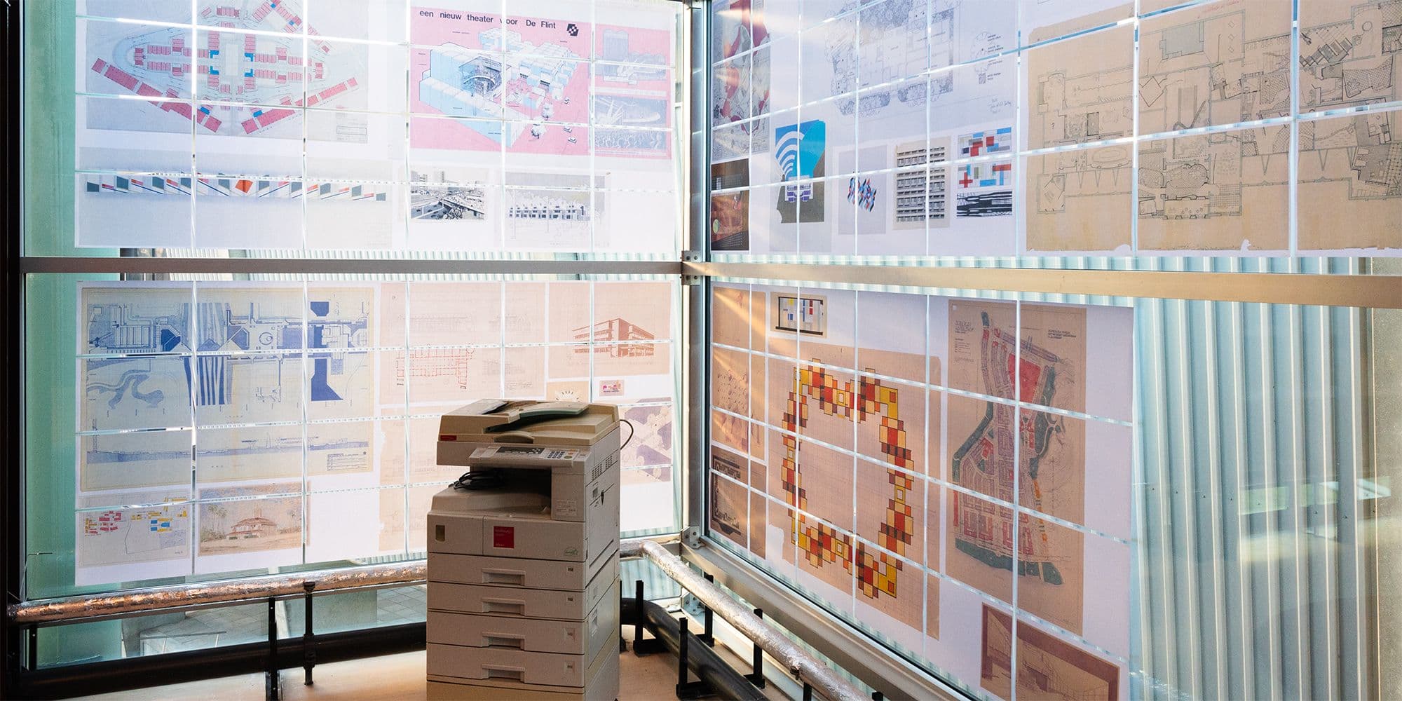 Copy Corner in het Research Centre. Ouderwets kopieerapparaat tegen een hoekraam die helemaal beplakt is met kopieen.