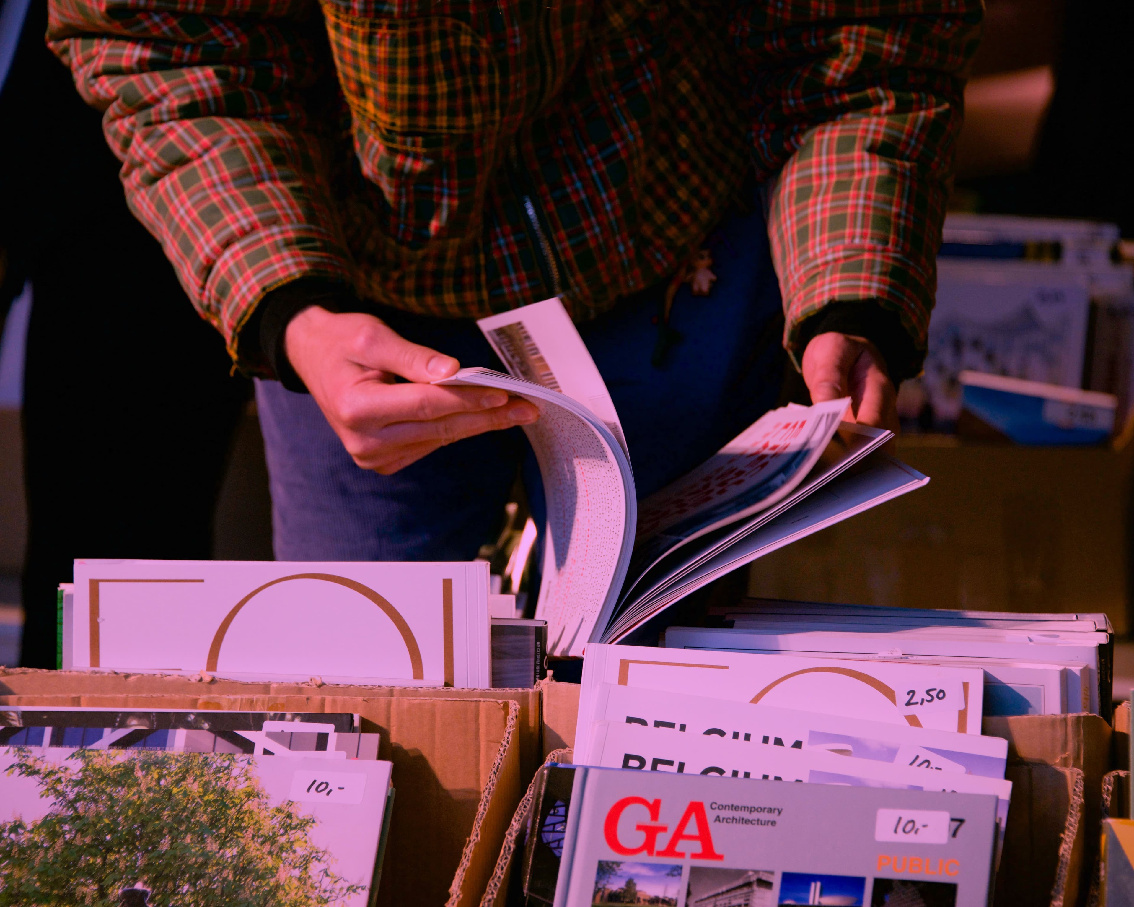 Close up of two hands browsing a magazine. Photo Isa de Jong