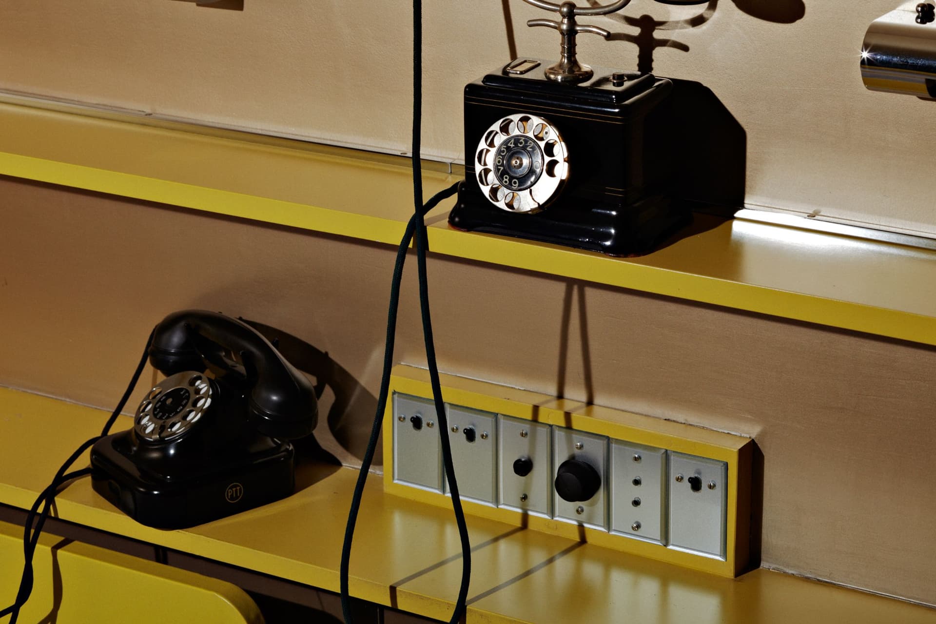 Two black, bakelite telephones on the shelves above the bed in the master bedroom. Photo Johannes Schwartz.