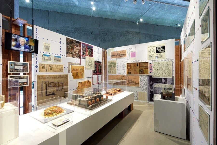Installation view of the exhibition, with models in the foreground, and drawings on the wall.