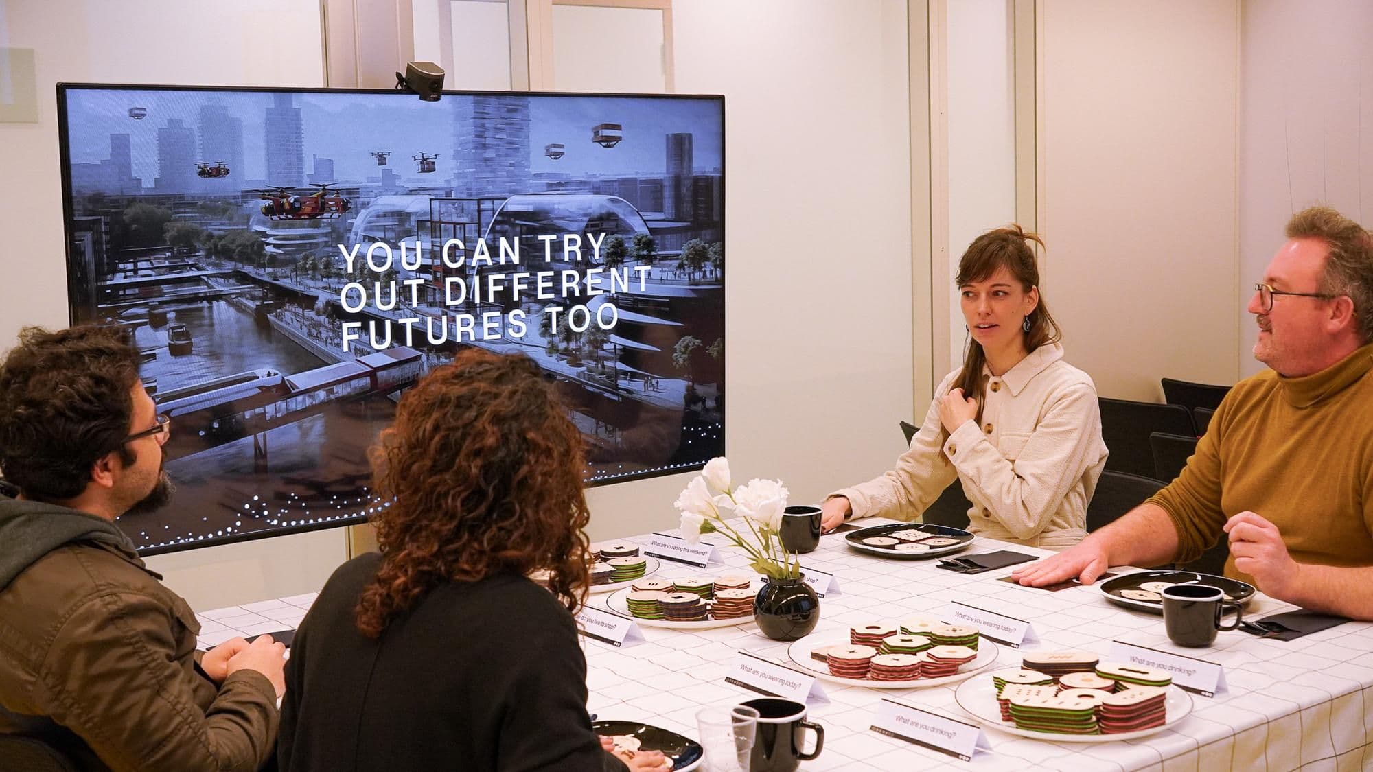 Presentatie over Haven-Stad, vier mensen aan tafel met een scherm. Foto: Akhil Sukumaran