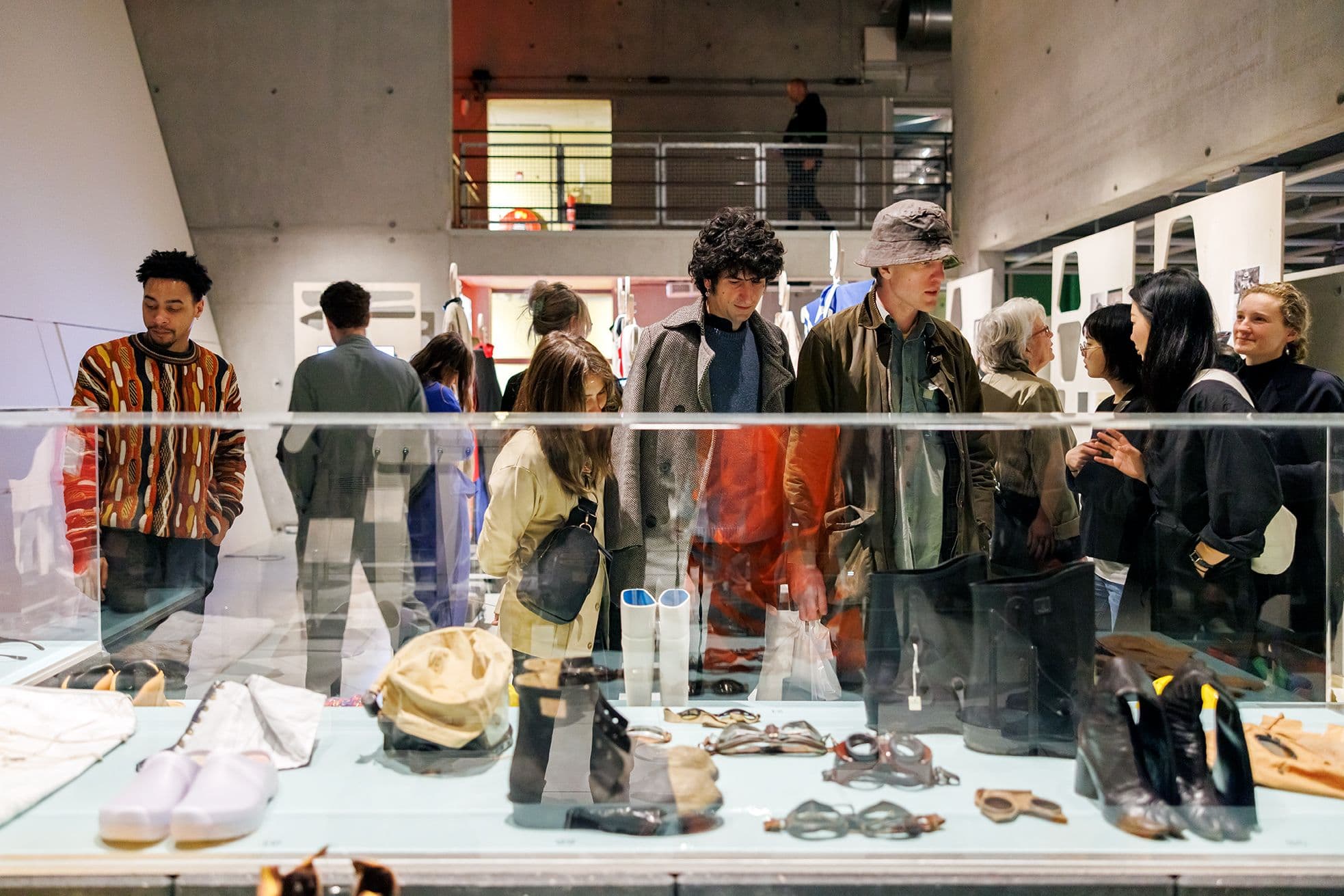 Visitors are viewing objects in a glass display case in front of them.