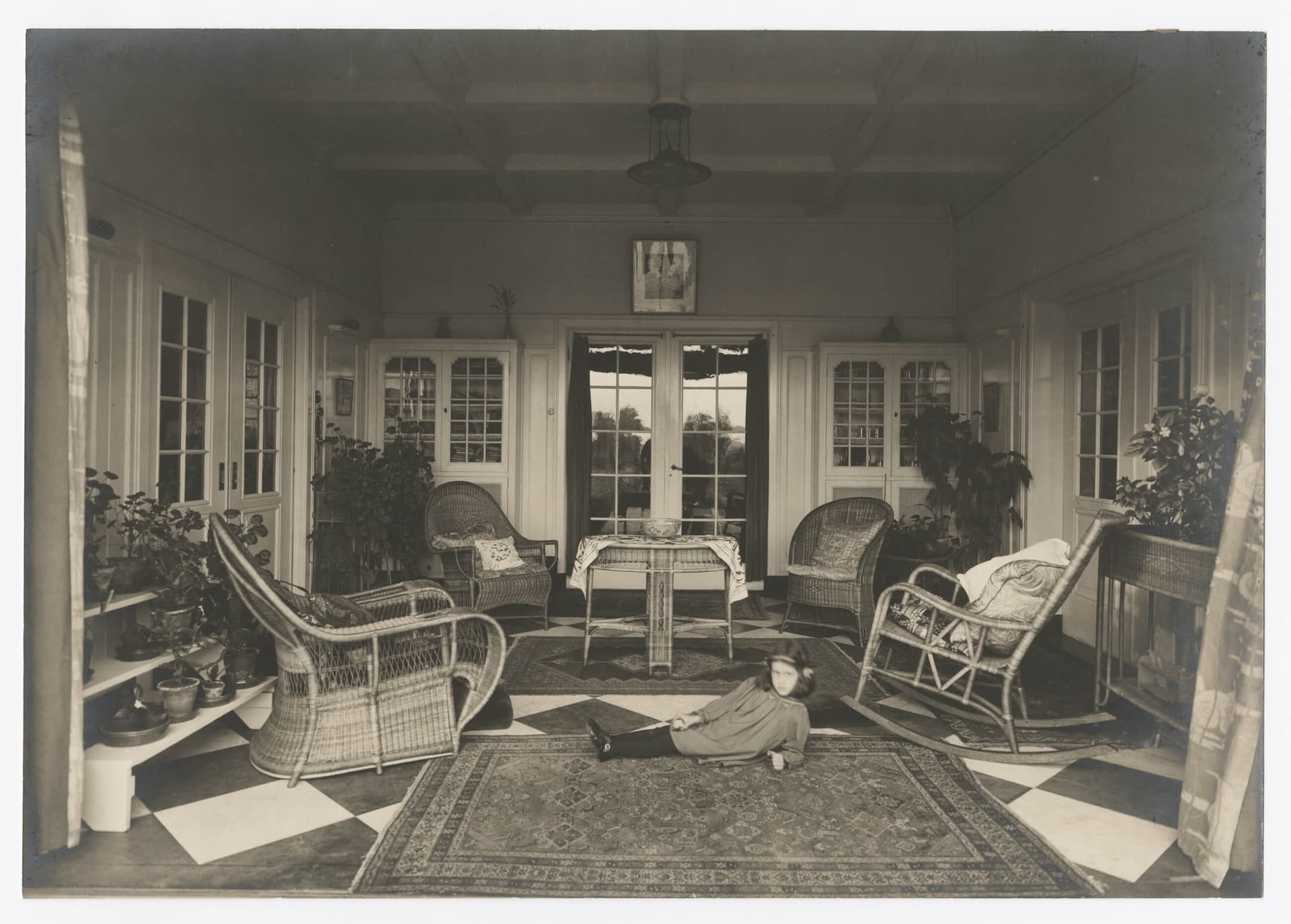 Isn’t this a bit strange? The living room isn’t short of chairs, yet a child is deliberately, defiantly almost, lying on the floor and pointedly staring straight at us. The interior looks like a nice place to visit, but the child makes it…  