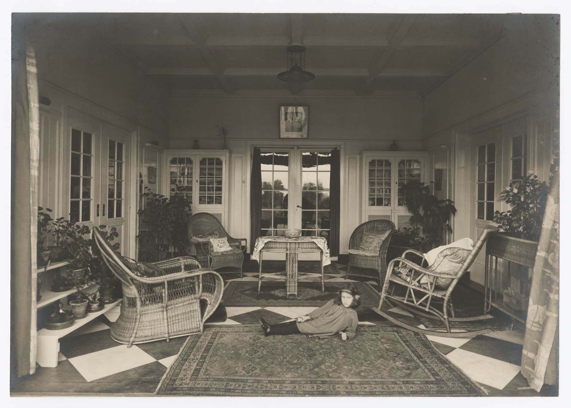 Isn’t this a bit strange? The living room isn’t short of chairs, yet a child is deliberately, defiantly almost, lying on the floor and pointedly staring straight at us. The interior looks like a nice place to visit, but the child makes it… 