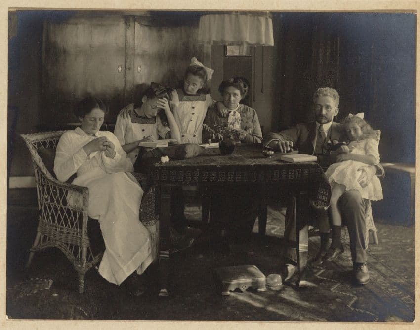 A family portrait that wouldn’t look out of place on Instagram: nonchalant, yet clearly posed. The interior, not too formal but not untidy, is equally calculated: the toys, books and sewing things seem to have been carefully chosen to crea… 