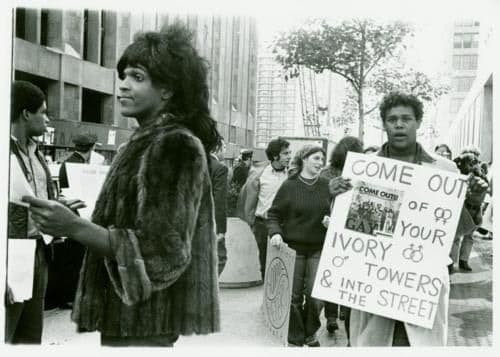 Marsha P. Johnson handing out flyers in front of NYU. Photo: Diane Davies, NYPL Digital Collections. 