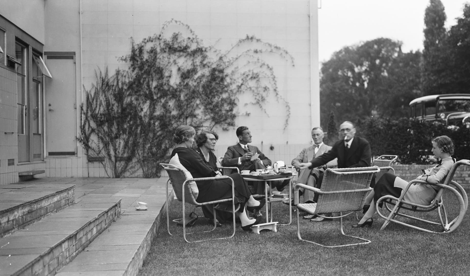 Familie Sonneveld en gasten in de achtertuin van Huis Sonneveld, naar ontwerp van J.A. Brinkman & L.C. van der Vlugt, in samenwerking met tuinarchitect Murk Leverland, ca. 1938. Collectie Het Nieuwe Instituut, bruikleen Stichting Behoud In… 