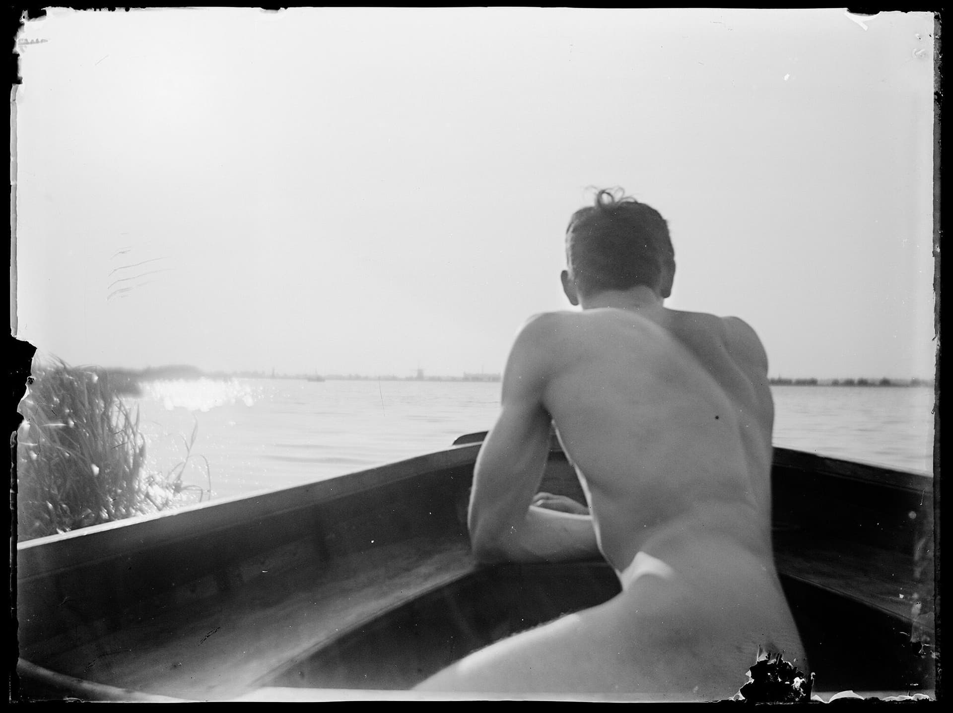 Unknown young man, naked in a boat. Glass plate negative from the archive of Eibink en Snellebrand. Collection Het Nieuwe Instituut, CAND eibi193 