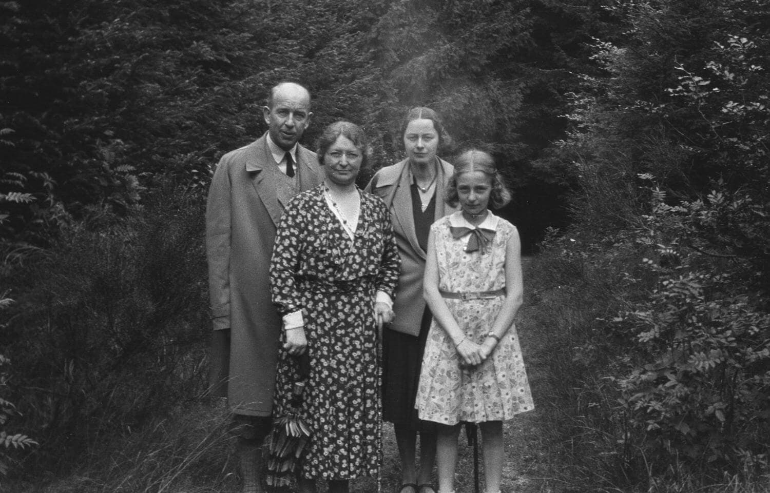 Een zwart-witfoto van familie Sonneveld, poserend buiten in een bosrijke omgeving.