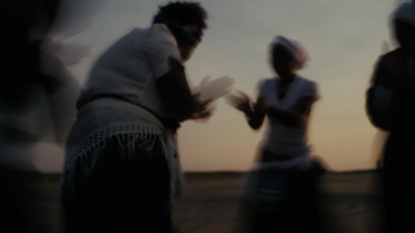 A group of dancing people with a blurry out-of-focus effect courtesy of Janilda Bartolomeu.