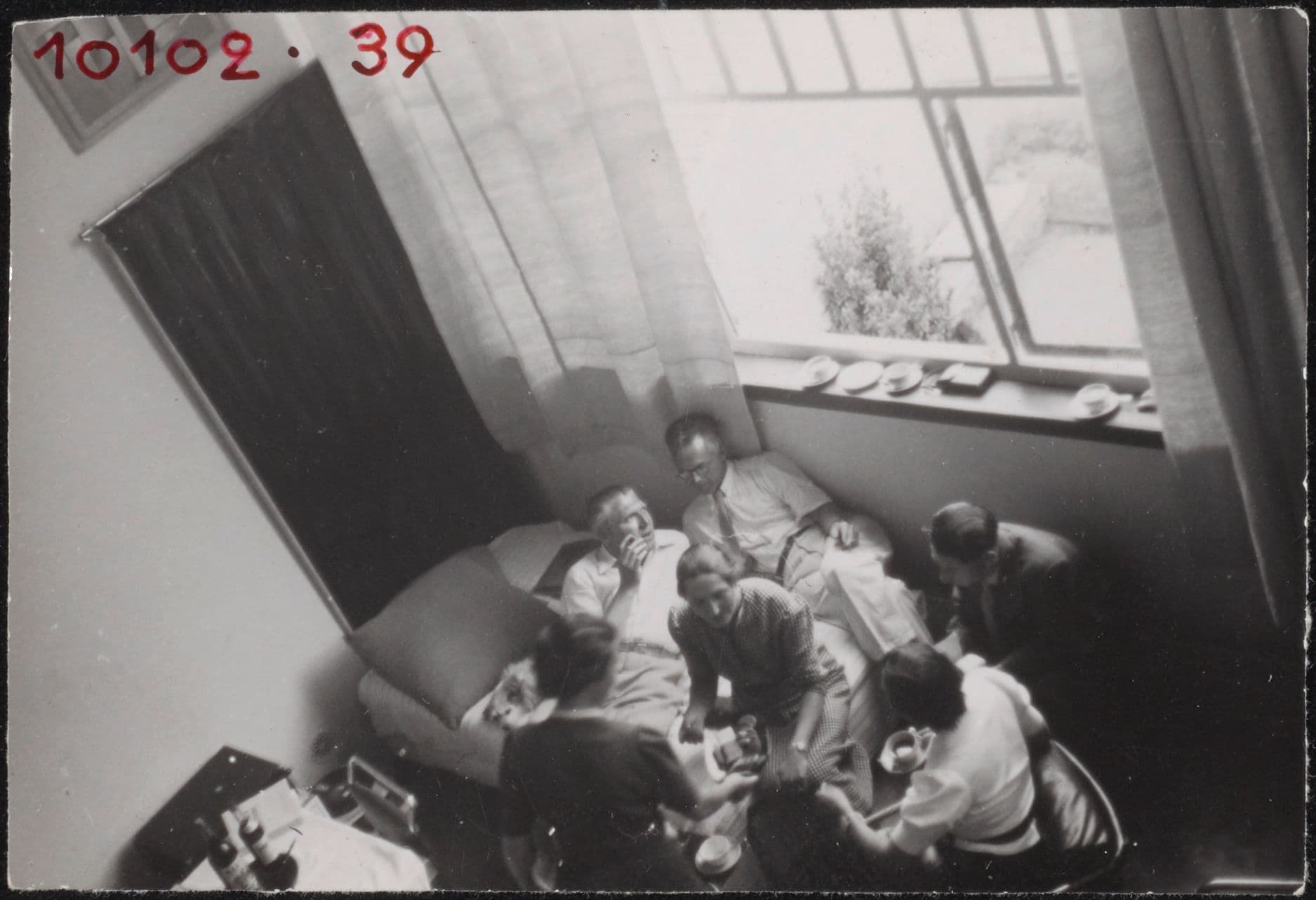 Guests, including Cornelis van Eesteren, in Theo and Nelly van Doesburg’s studio-house in Meudon-Val-Fleury. Photograph by Piet Zwart, possibly taken during the CIAM conference in Paris in 1937. Collection Het Nieuwe Instituut, ZWAR ph723. Copyr…