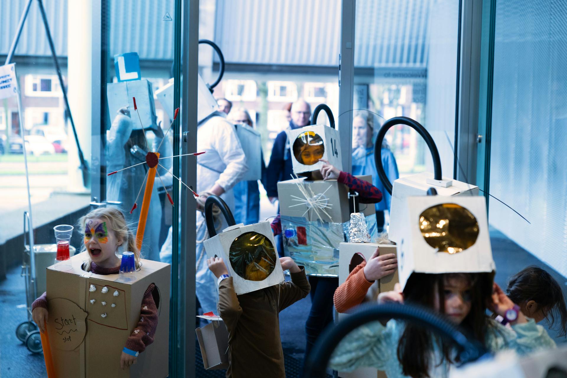 Een groepje kinderen met zelfgemaakte ruimtepakken zijn samen aan het spelen.
