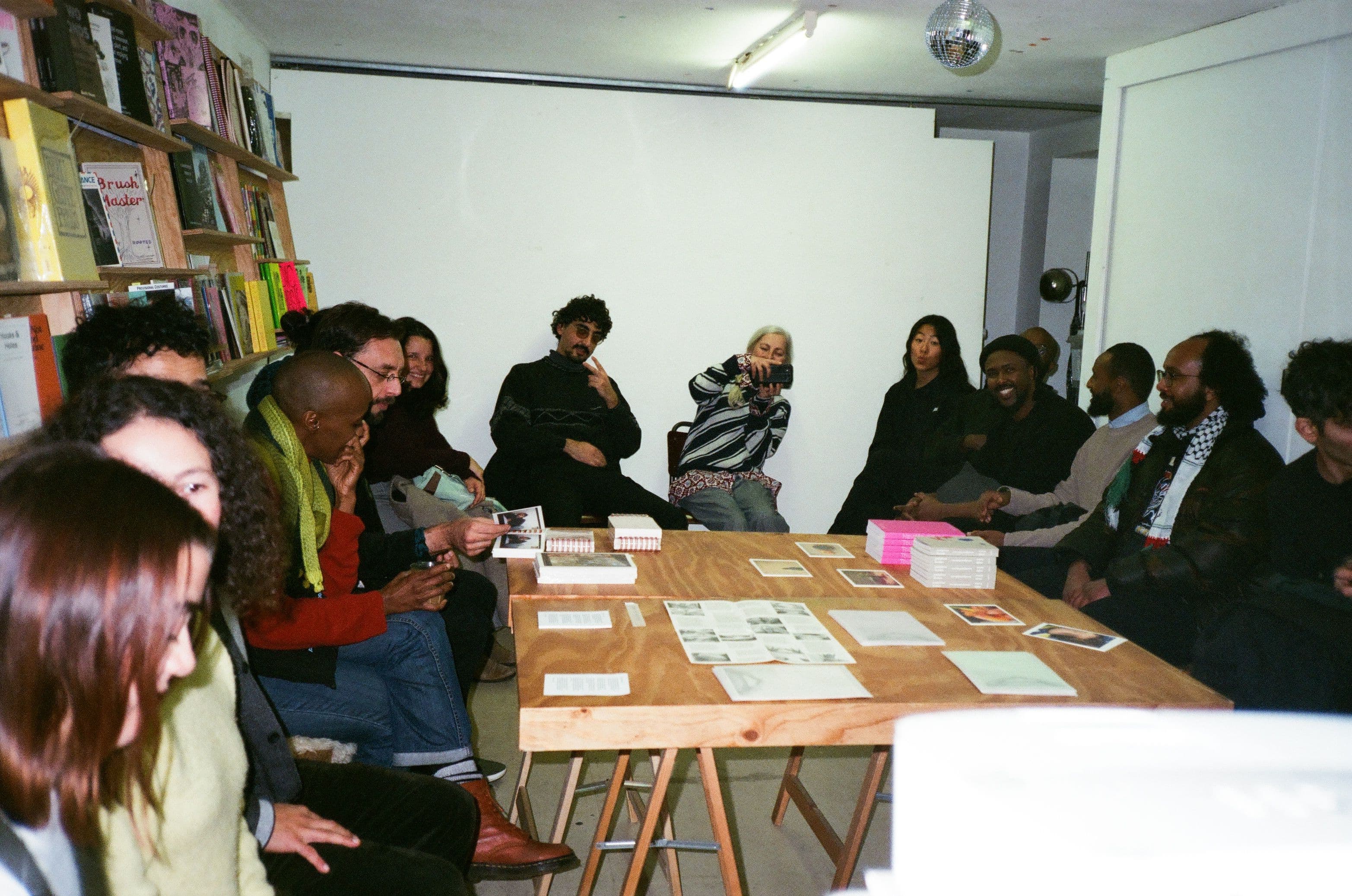 Group of visitors sitting around a table with books