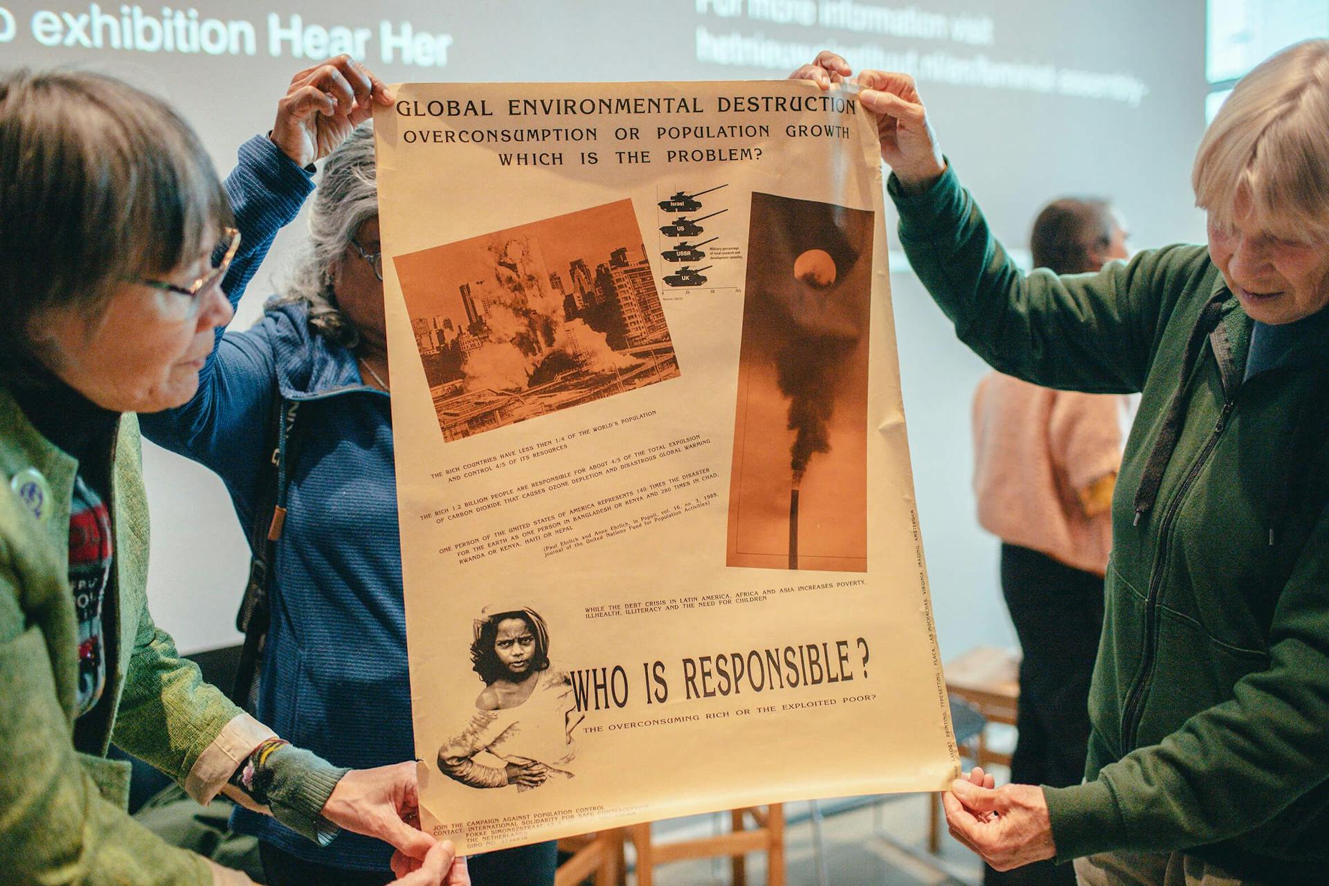 Tineke E. Jansen, Sumati Nair and Jenneke Arens holding a poster with the title “Who is responsible?” designed by Sumati Nair, printed by Vrouwendrukkerij Virginia, 1989(?), during Roundtable #3 on Posting as a feminist design strategy, Fe… 