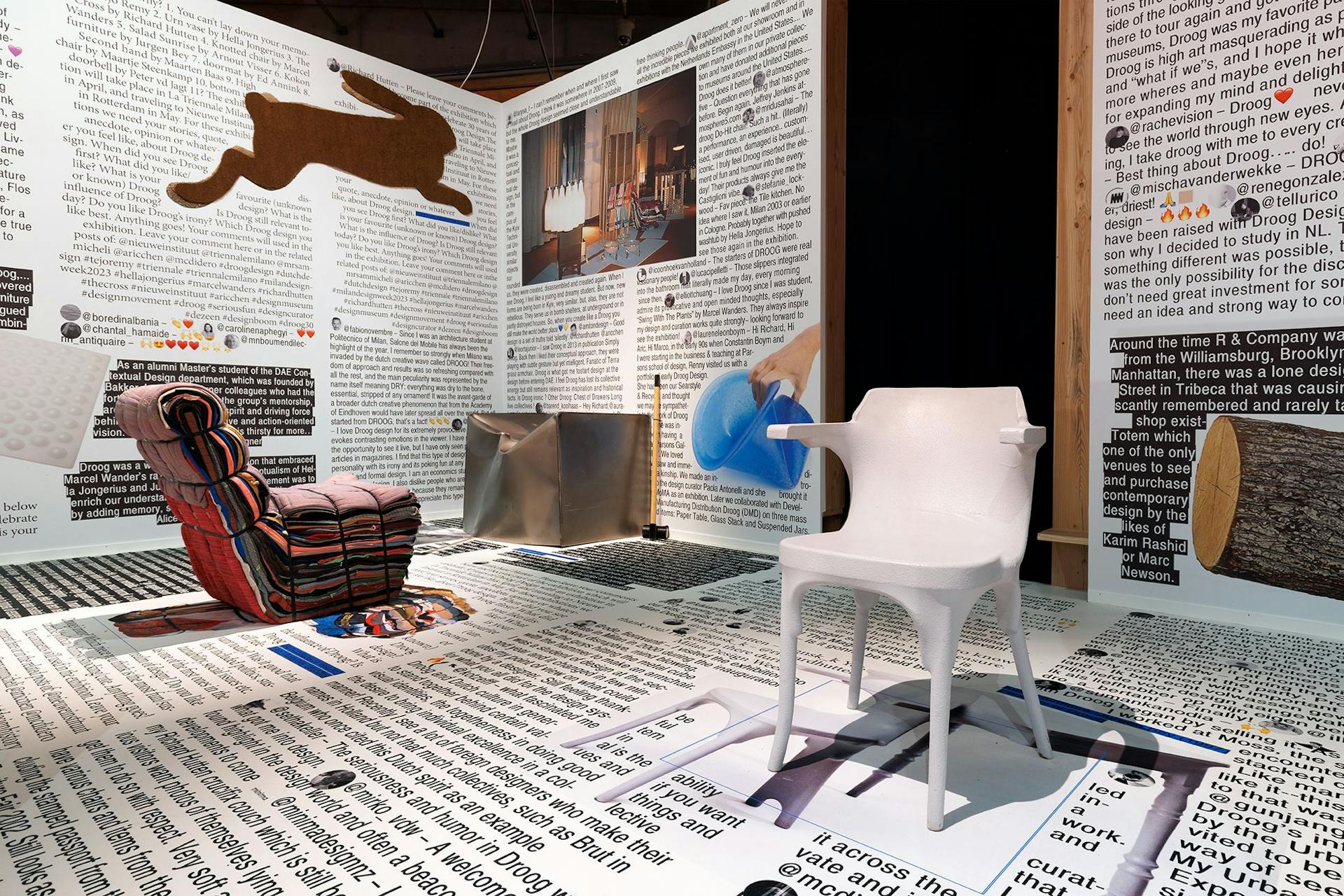 Foto van een tentoonstellingsruimte met daarin diverse meubels en designobjecten in onconventionele vormen en materialen. Op de muren en de vloer zijn teksten in uiteenlopende lettertypes en kleuren.