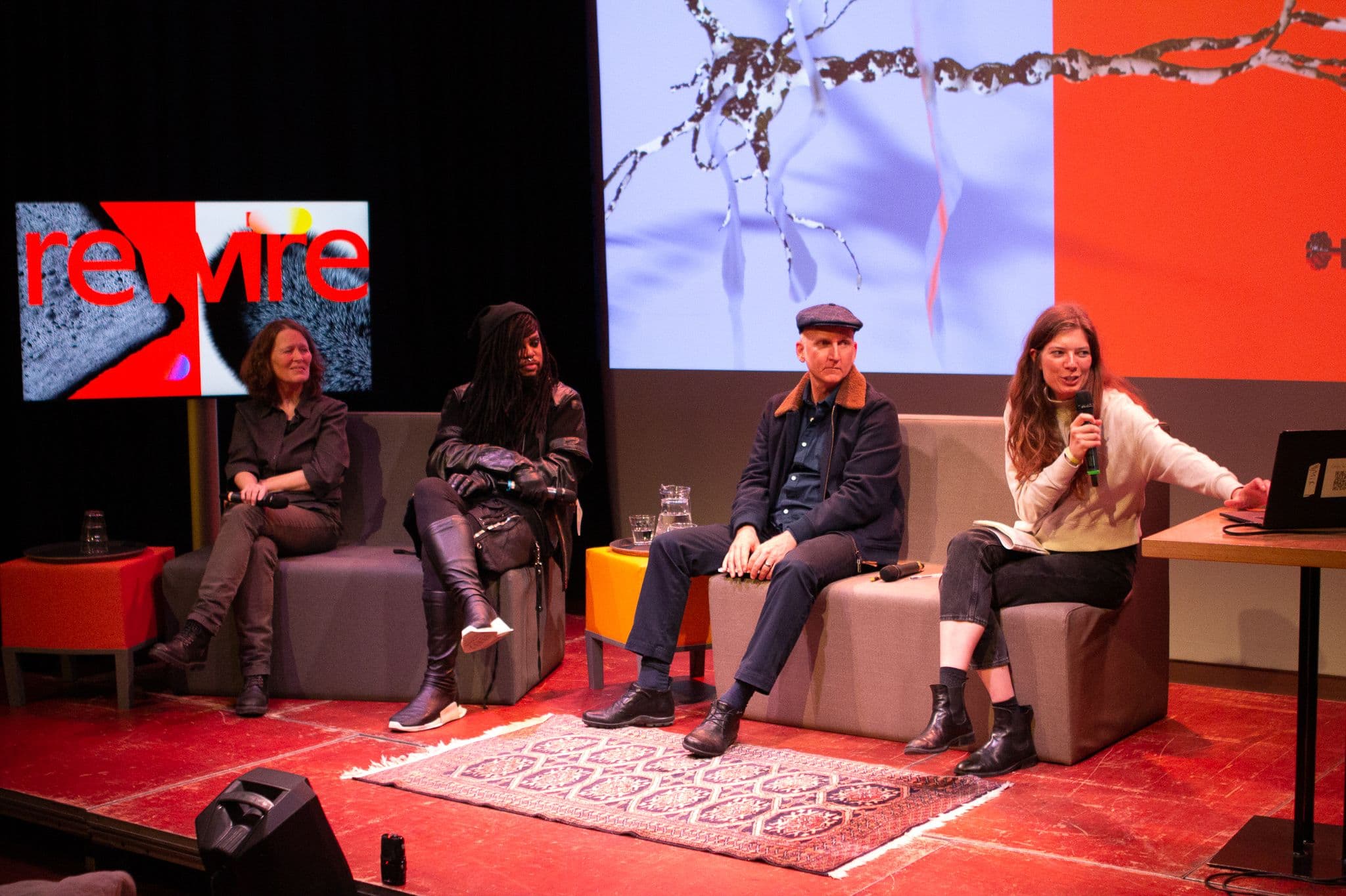 Four people on stage in a panel conversation