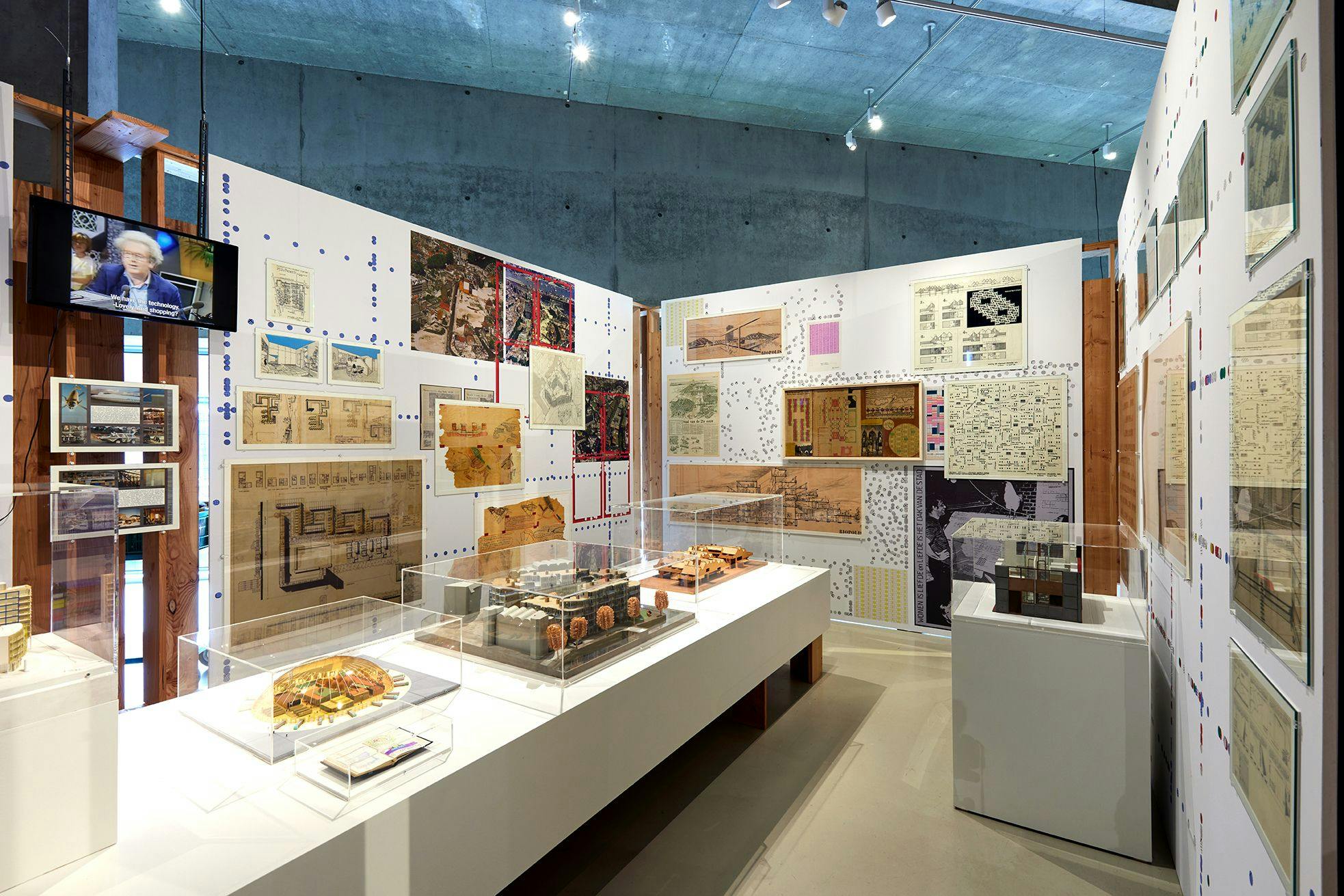 Installation view of the exhibition, with models in the foreground, and drawings on the wall.