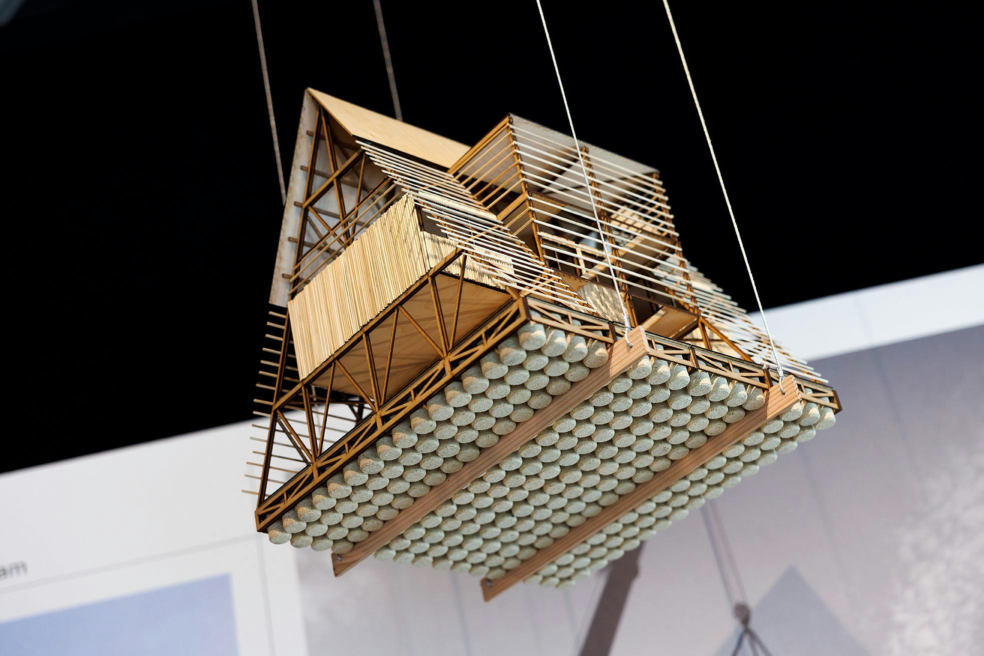 Een model van het drijvende paviljoen hangt aan draden in de tentoonstelling Waterstad.