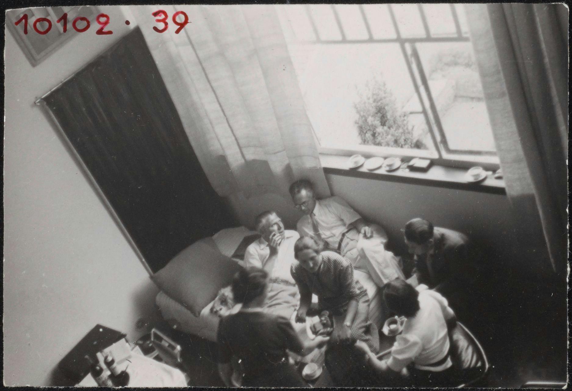 Gasten, waaronder C. van Eesteren, in de atelierwoning van Theo en Nelly van Doesburg te Meudon-Val-Fleury. Foto Piet Zwart, mogelijk genomen tijdens de CIAM conferentie in Parijs, 1937. Collectie Het Nieuwe Instituut, ZWAR ph723. Copyrigh… 